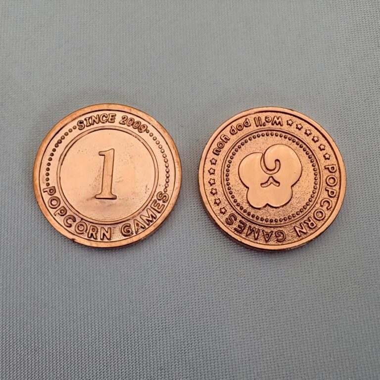 Two copper plated zinc alloy board game coins showing value 1 face and publisher logo reverse, custom OEM game currency